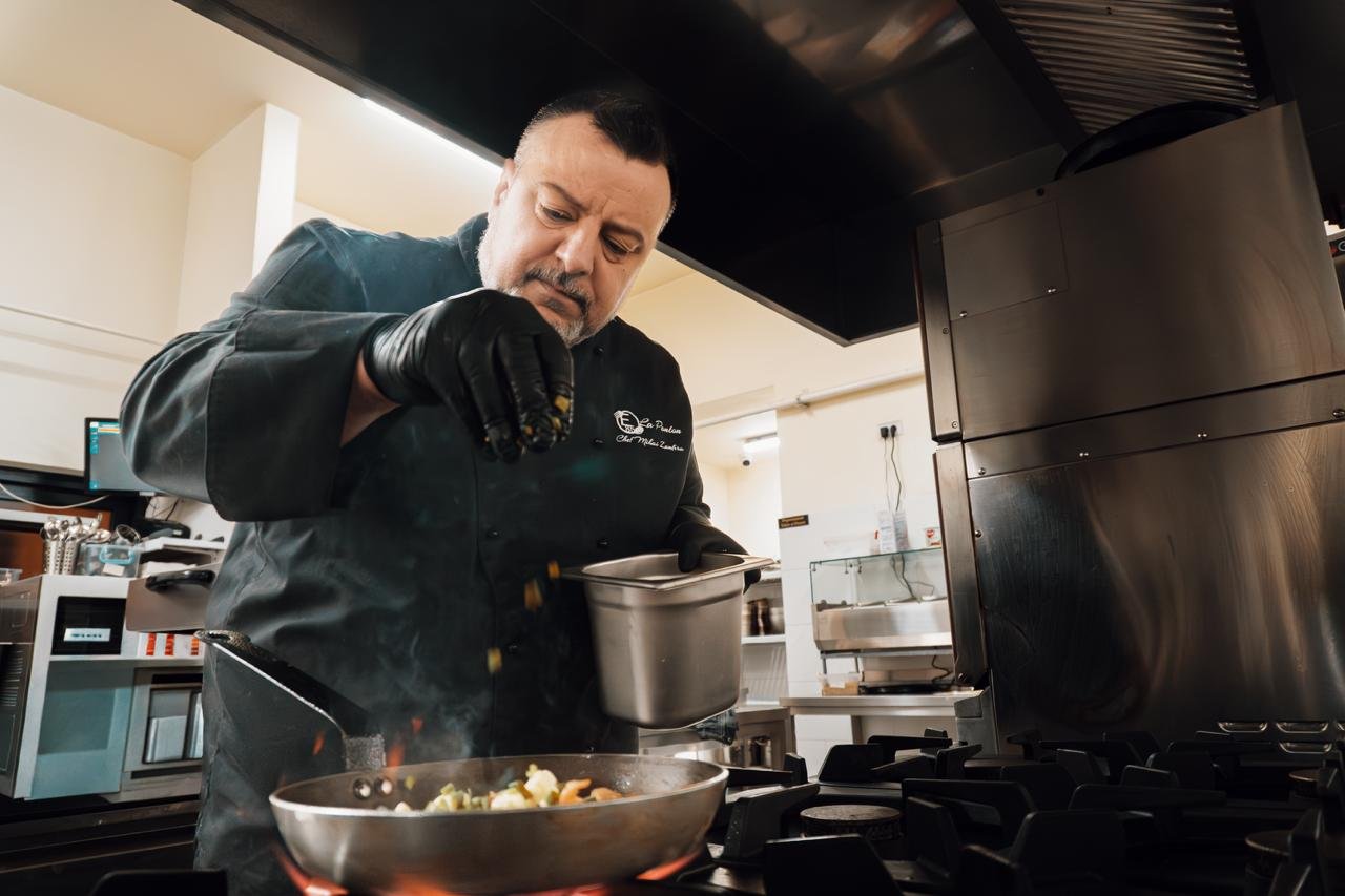 Chef finalizând un preparat la pasul de servire într-o bucătărie profesională