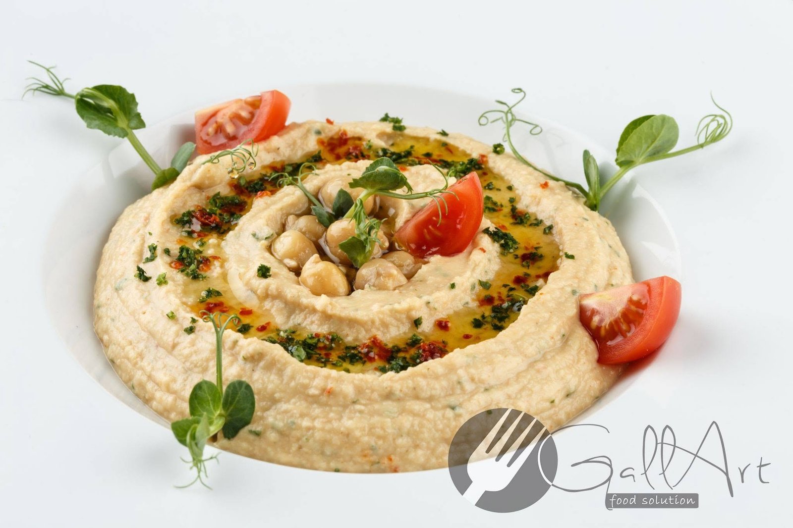 Hummus de năut cu ulei de măsline, ierburi și tomate.